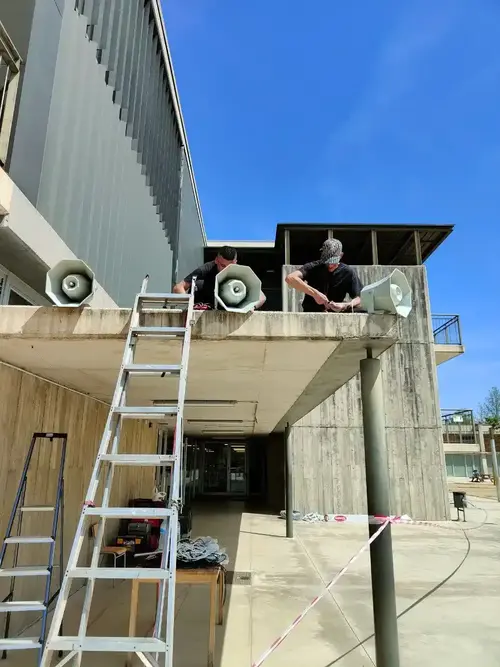 Trabajos de instalación de megafonía en el patio de un instituto